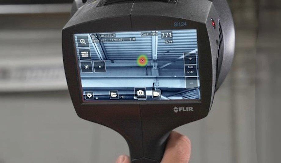 The screen of a FLIR acoustic camera showing an acoustic hotspot at a leak, with flow and cost readouts